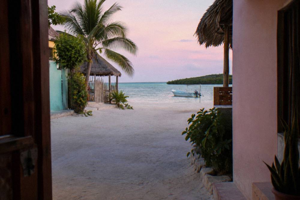 Empty sandy street in Holbox village at first light with pastel walls and soft dawn sky