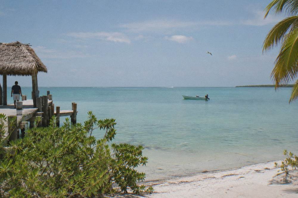 A wide flat sea under morning light with a distant boat and low horizon line