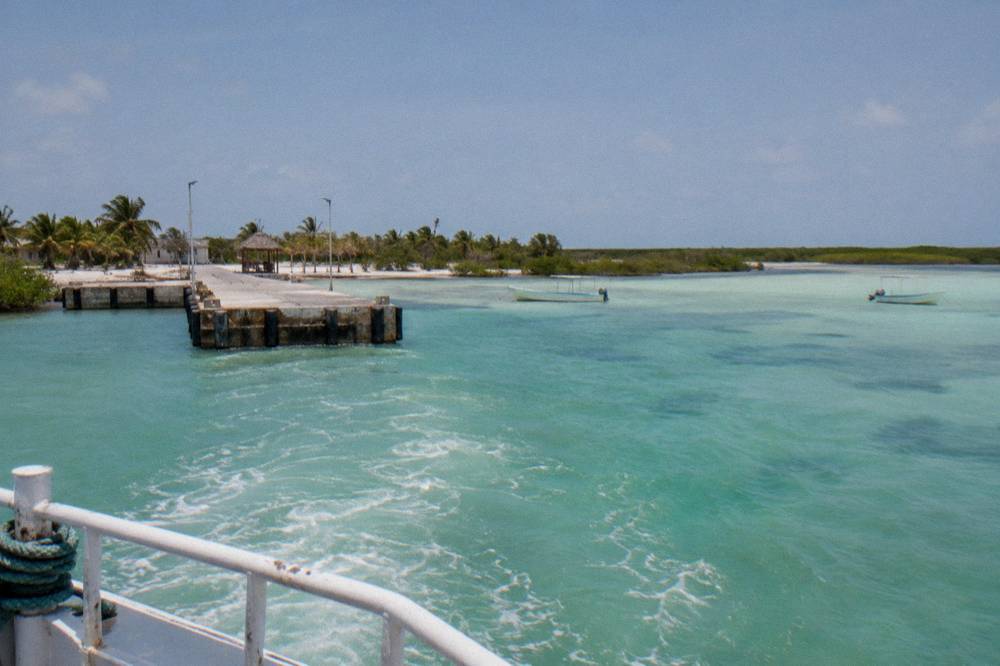 Shallow turquoise water and sandy bottom seen from a small boat crossing toward Holbox