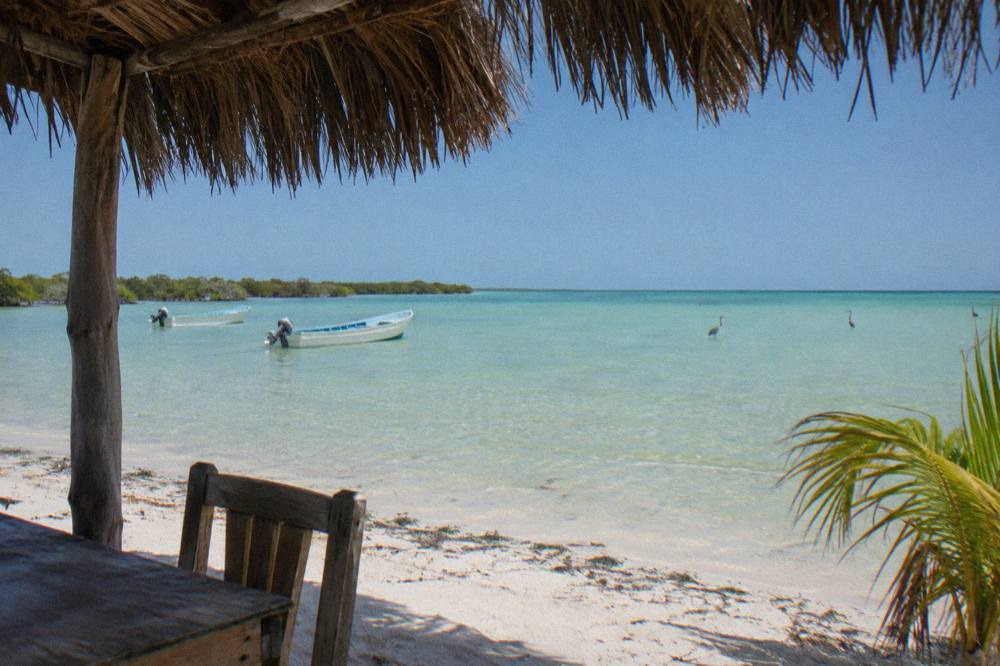 Shallow clear water and pale sand along a quiet Holbox beach at midday