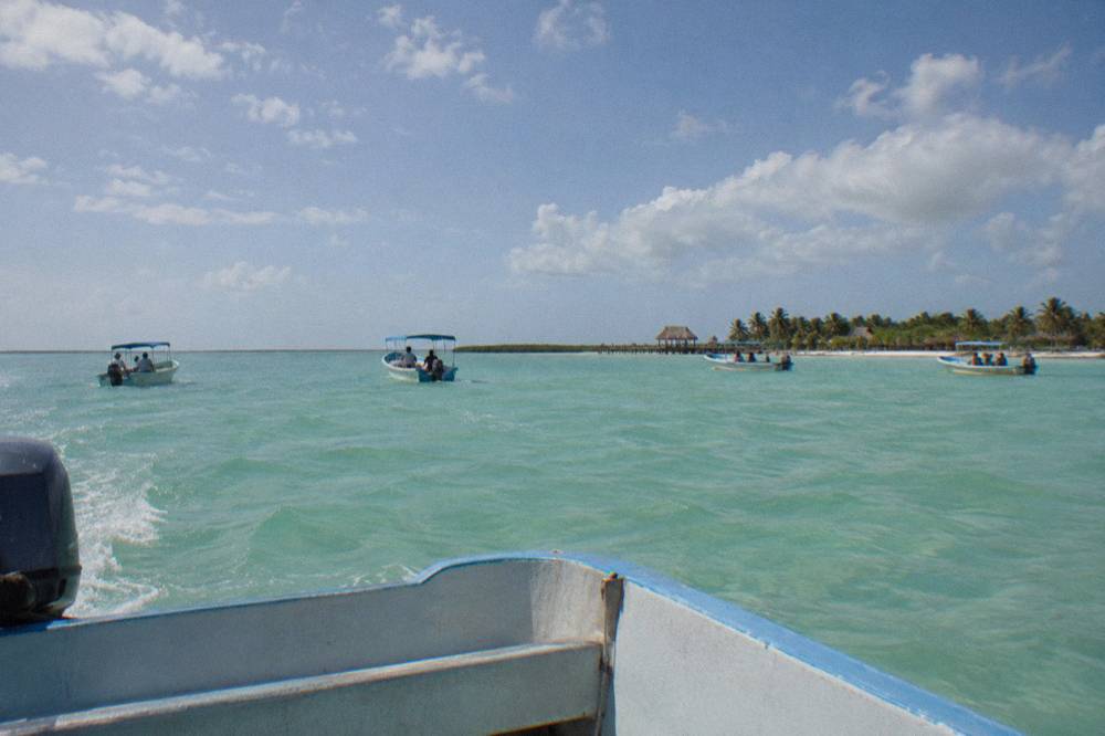  Several boats spaced apart on open blue sea under a wide sky with scattered clouds