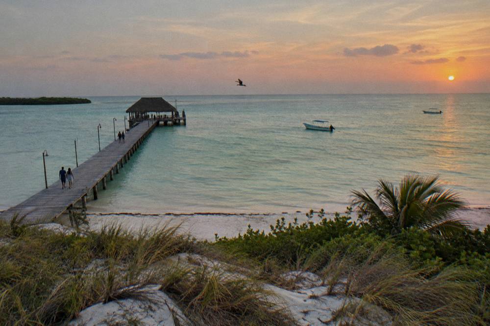 Wide open sea horizon with two distant small boats near a protected marine area