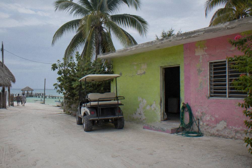 Quiet sandy street on Holbox with colorful painted murals and bicycles leaning against a wall