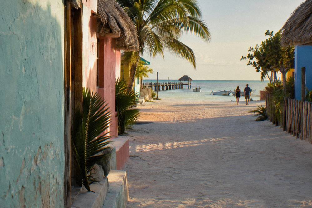 A quiet island street with sand roads and pastel painted buildings